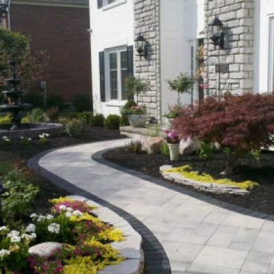 Colorful landscaping, stone walls, fountain, stone walkway